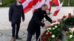 Prezydent Jerzy Łużniak składa kwiaty pod pomnikiem, w asyście przewodniczącego rady miejskiej Wojciecha Chadży.