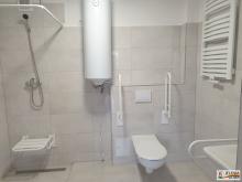 Toaleta z prysznice, wc, poręczami dla osób z niepełnosprawnościami.