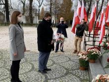 Poseł Robert Obaz składa kwiaty.