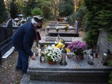 Harcerze układają kwiaty na grobach.