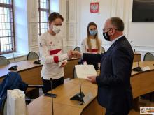 Prezydent wręcza upominki medalistom.